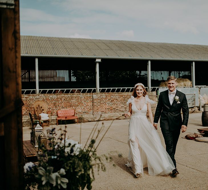 Bride in Inbal Dror wedding dress at rustic barn wedding reception 