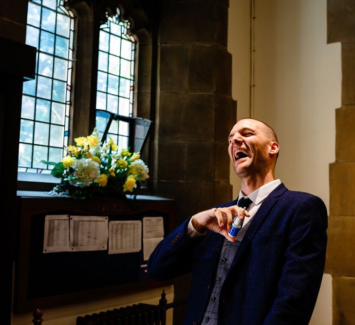 Groom in Navy suit and checked waistcoat at the altar 