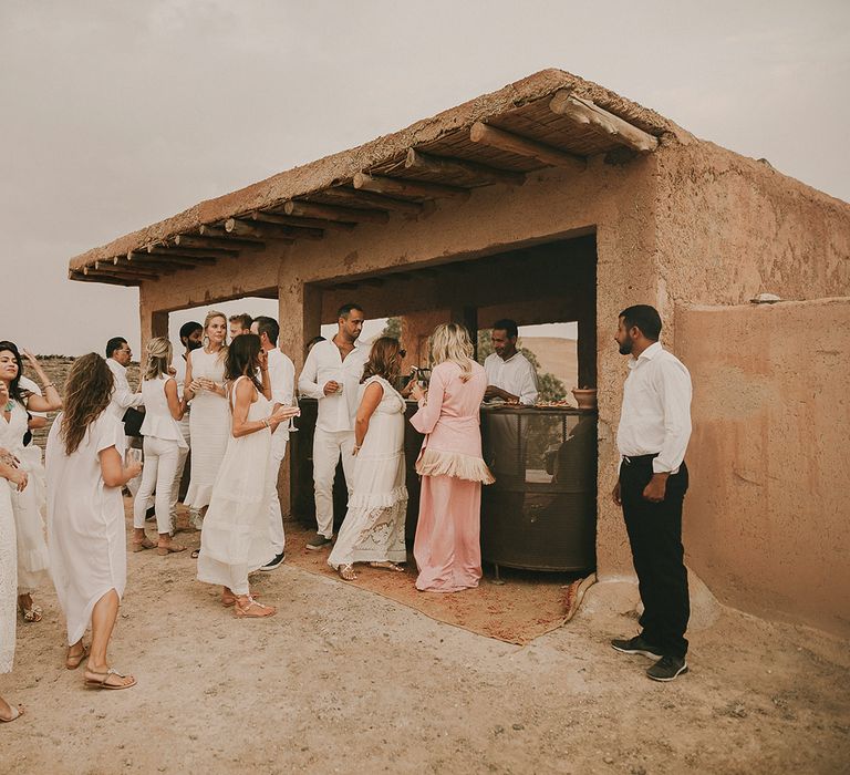 Wedding guests all dresses in white at desert wedding 