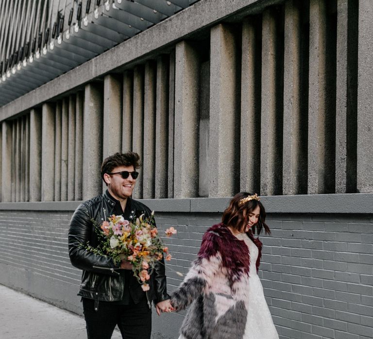 Bride & groom walk whilst laughing in New York