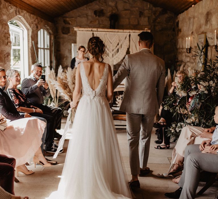 Bride and Groom walking up the aisle in rustic ceremony