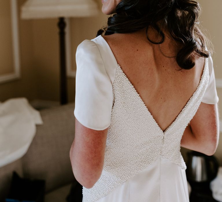 Brunette bride wears embellished low back V-neck wedding dress