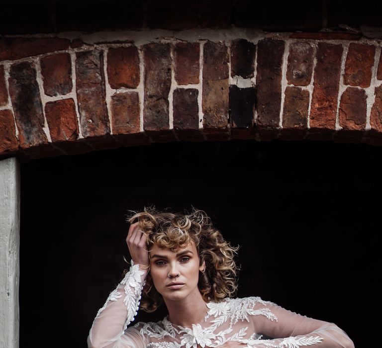 The bride poses with short curly wedding hair at Sedgewell Barn