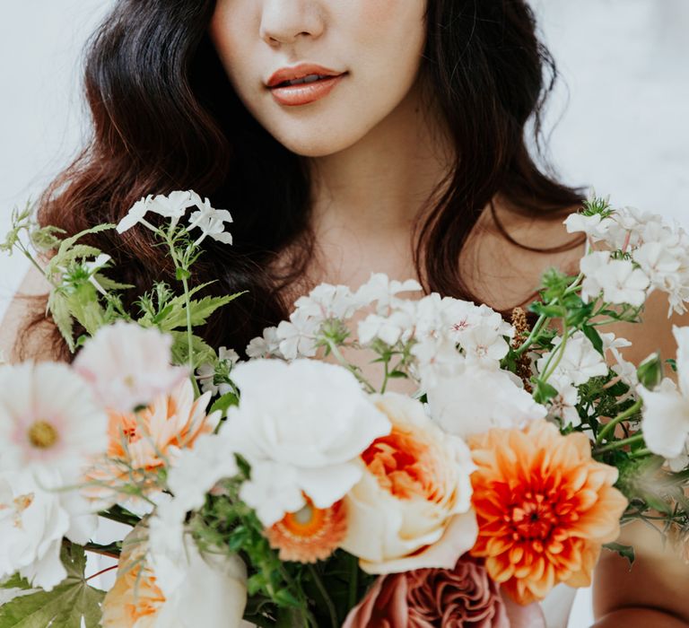 Asian bride wearing a floral hair clip for a white and gold wedding