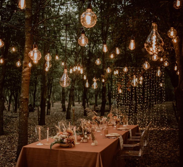 intimate forest wedding reception with fairy light curtain and festoon light canopy 