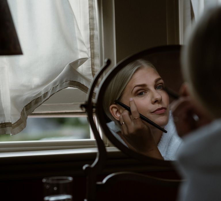 Bride does her makeup on the morning of her wedding