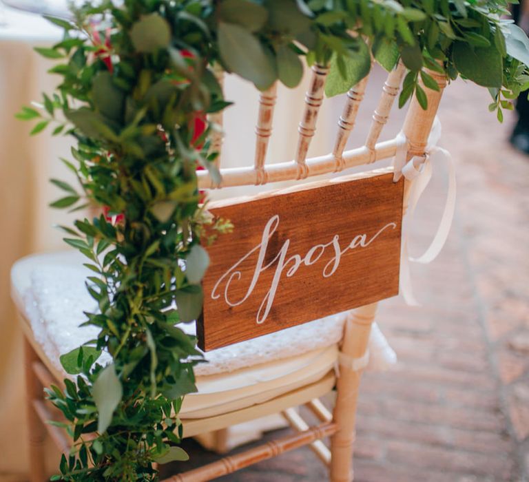 Bride's chair with a wooden sign reading 'Sposa'