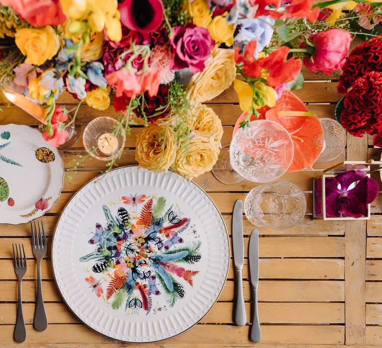 Colourful table setting with printed plates in bold colours and bright bouquets