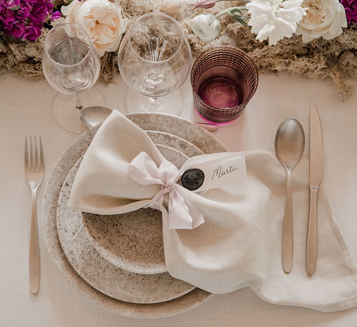 Place setting with patterned tableware and linen tablecloth 