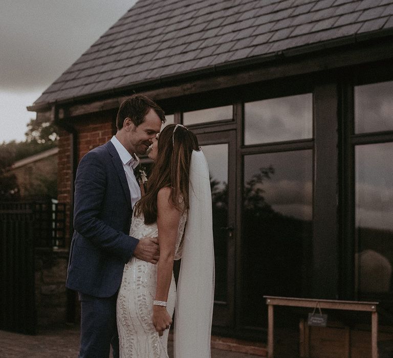 Bride & groom kiss outdoors on their wedding day