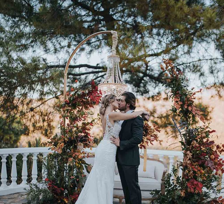 Bride and groom at intimate elopement with Autumn colour wedding flowers and chandelier decor