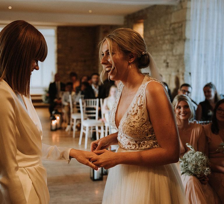 Brides exchange rings during ceremony at The Great Tythe Barn venue