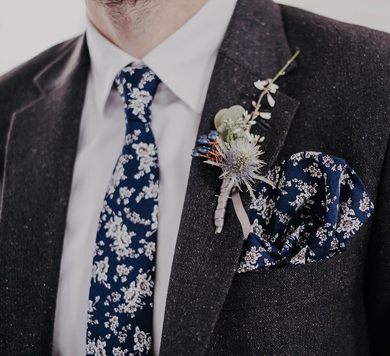 Groom wears patterned tie and matching pocket square complete with floral buttonhole 