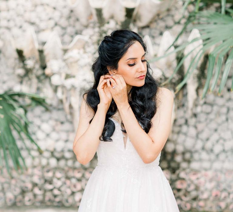 Bride puts in her earrings on her wedding day