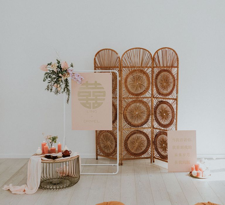 Modern asian wedding decor with pillar candles and wicker detailed backdrop