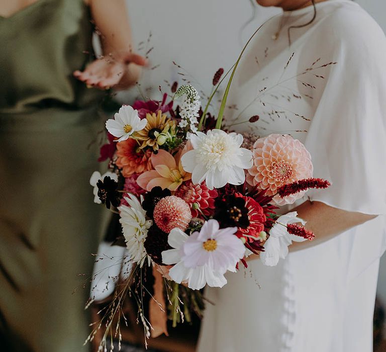 Bride holds brightly coloured floral bouquet on the morning of her wedding day | Irene Yap Photography