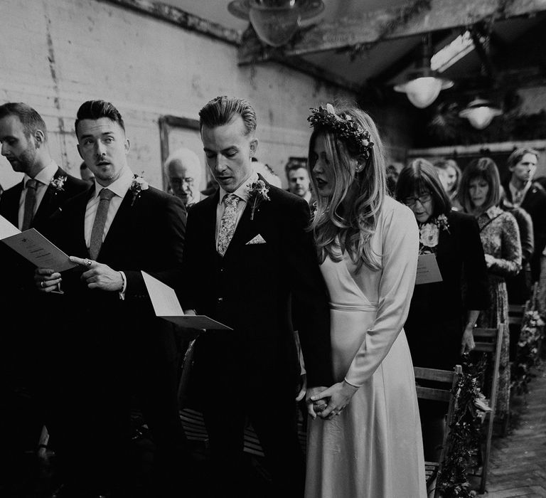 Bride & groom read from hymn sheet on their wedding day