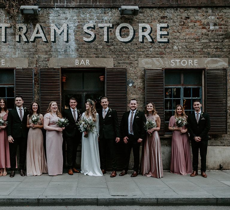 Bride & groom stand with their wedding party on their wedding day