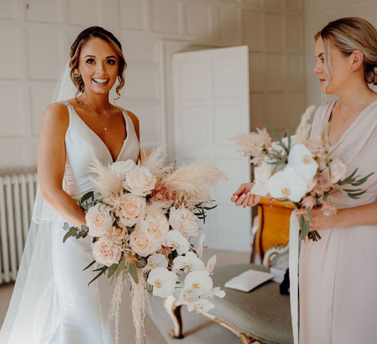 Bride in mermaid fishtail wedding dress holding a blush pink wedding bouquet with pampas grass, roses and orchids bu Corky & Prince 