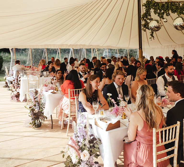 Marquee filled with wedding guests for pink themed wedding for summer in England 