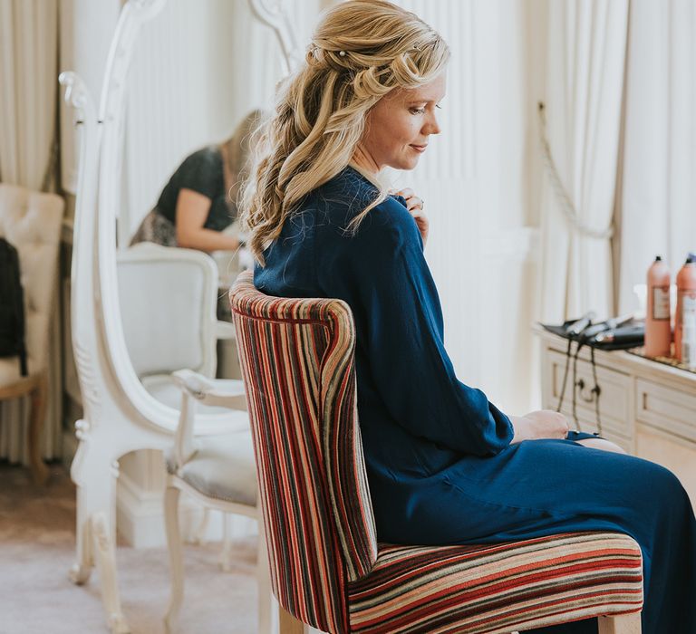 Bride with half up half down wedding hair with pearl hair pins in blue satin pyjamas 