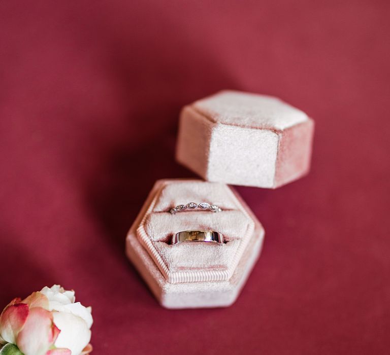 Pink velvet hexagon ring box with the wedding bands for the bride and groom 