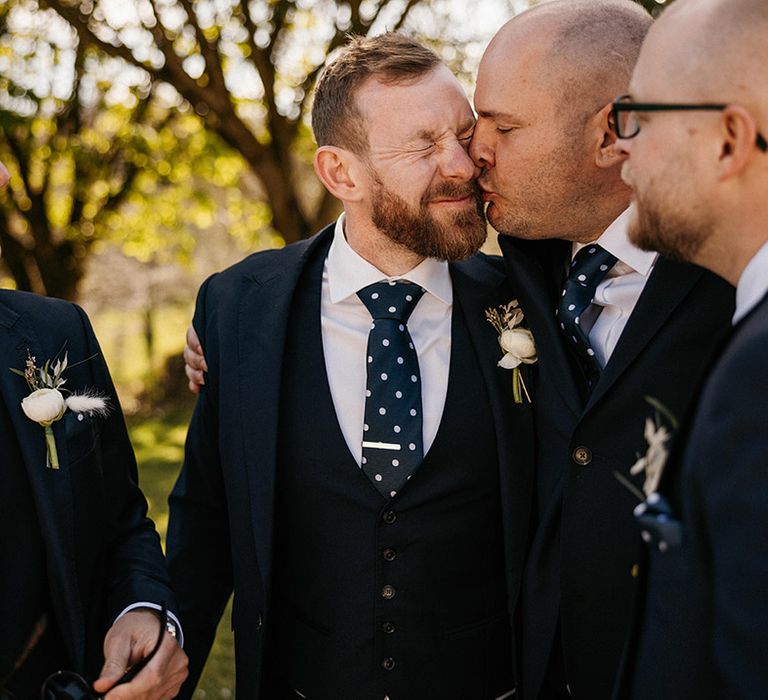 Groom with groomsmen in matching blue suits with polka dot ties 