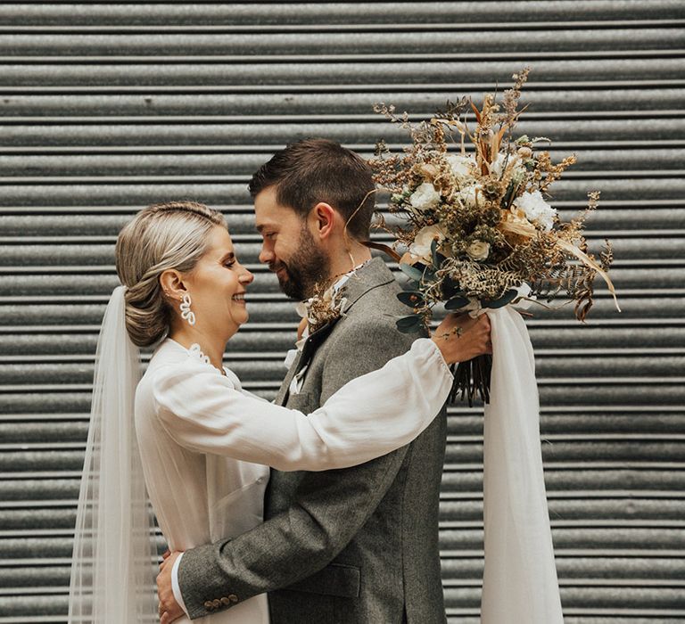 Bride wears long sleeve Reformation wedding dress with cathedral veil 