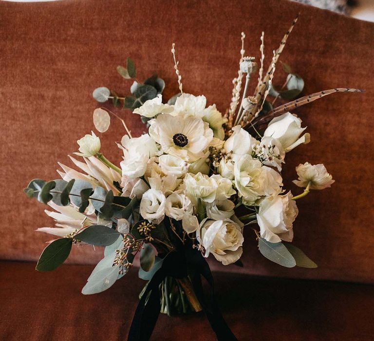 Minimalistic mixed white floral bouquet with foliage leaf decorations and black velvet ribbon