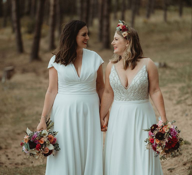 Bride in Freda Bennet wedding dress with the bride in a Justin Alexander wedding dress with colourful bouquet 