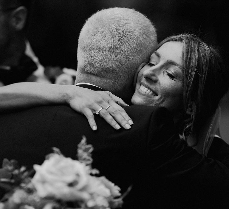 The bride shares a special moment with the father of the bride as they hug 