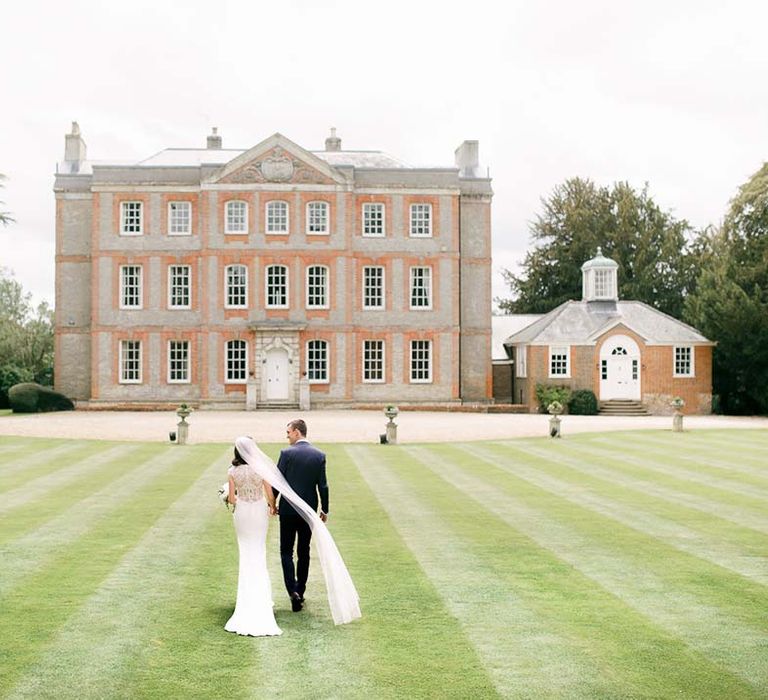 Bride and groom walking I the grounds of their Ardington House Oxfordshire wedding venue