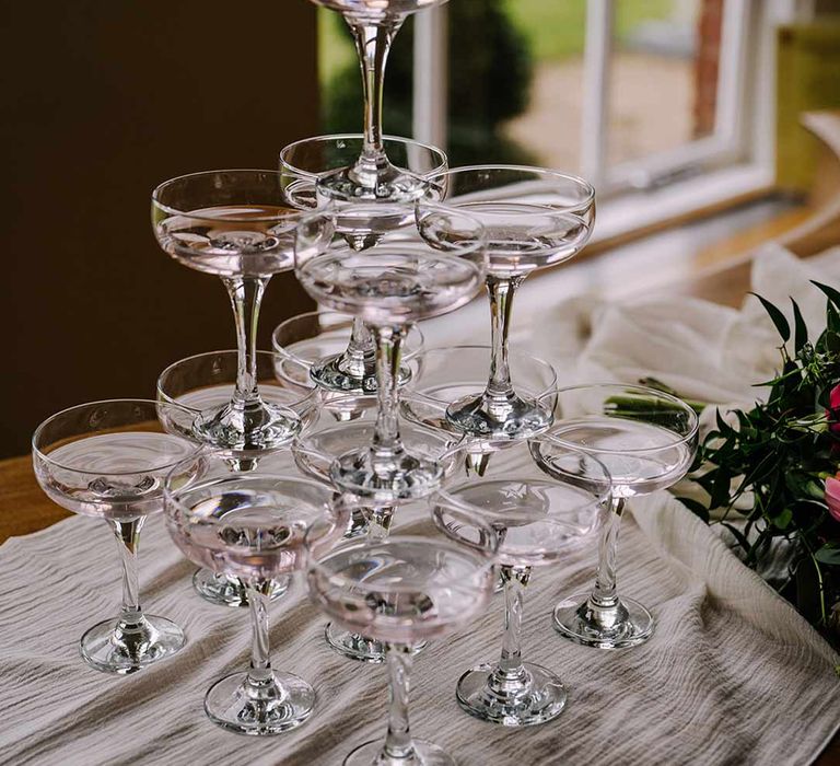 Classic wedding champagne tower on white wedding tablecloth 