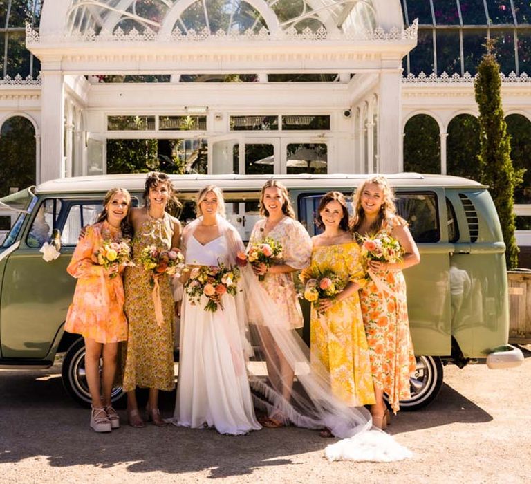 Bridesmaids in yellow floral mismatched bridesmaid dresses with the bride in Catherine Dean two piece set 