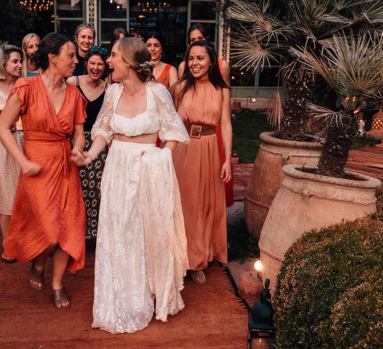 Wedding guests in orange and red wedding outfits for destination wedding in Marrakech 