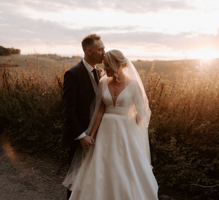 Bake Barn wedding with the bride and groom posing together during sunset 