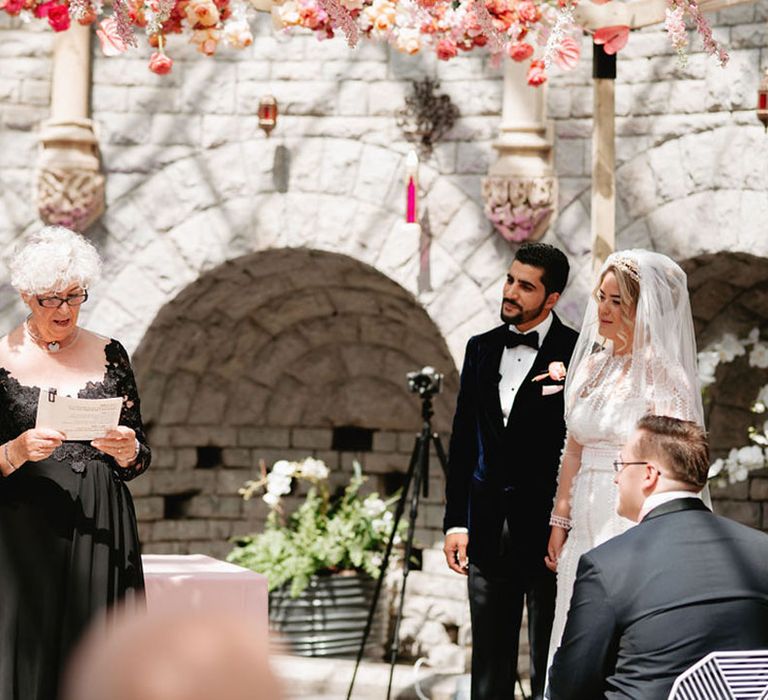 Woman in black sparkly dress performs the wedding ceremony for the bride and groom at De Vere Tortworth Court Wedding 