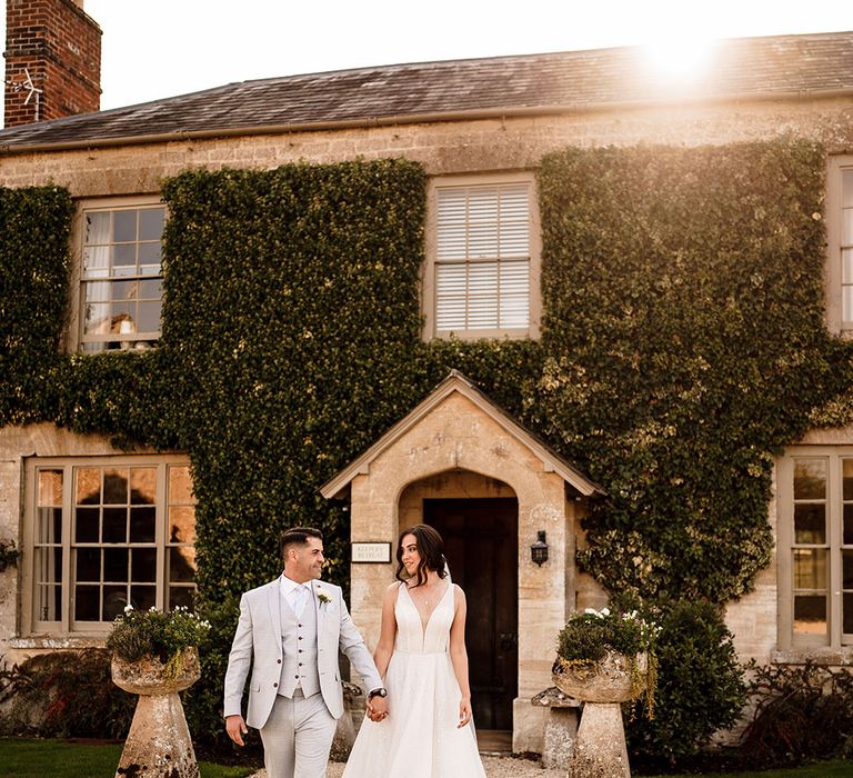 Rustic luxe wedding at Caswell House wedding venue in Oxfordshire with bride in a Gabbiano wedding dress and groom in a light blue check wedding suit 