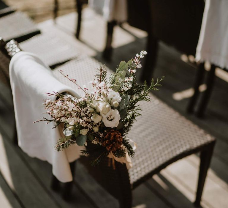 Aisle chair flower arrangements with white garden rose, eucalyptus, baby's-breath and foliage