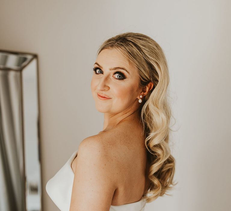 Bride with long blonde bouncy curled wedding hair in strapless gown 