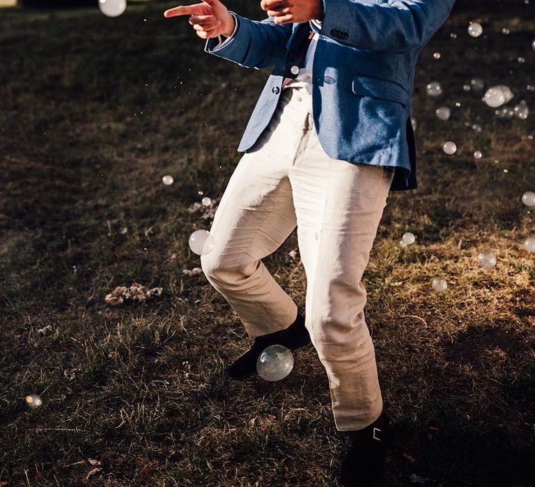 Wedding guest poses with smoke filled bubbles around him 