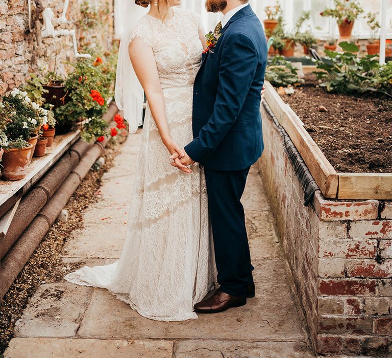 Bride in boho lace gown by Willowy by Watters standing with the groom at their September wedding 