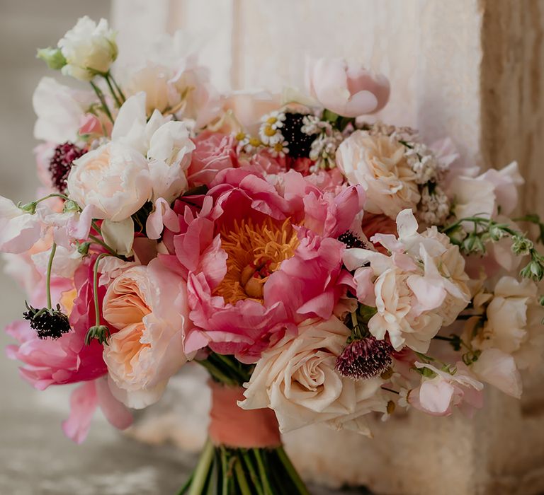 Wedding bouquet with pink chinese peonies and blush peonies with coral ribbon wrapped around stems