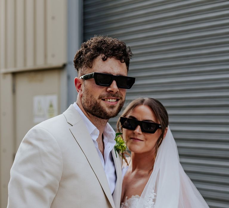 The happy couple smiling wearing black wedding sunglasses accessories 