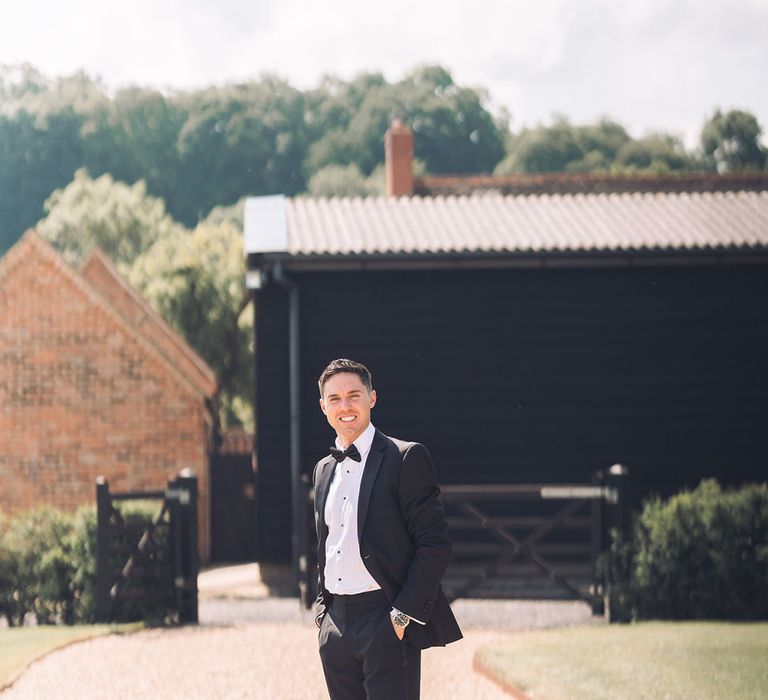 Groom in a tuxedo at rustic luxe wedding 