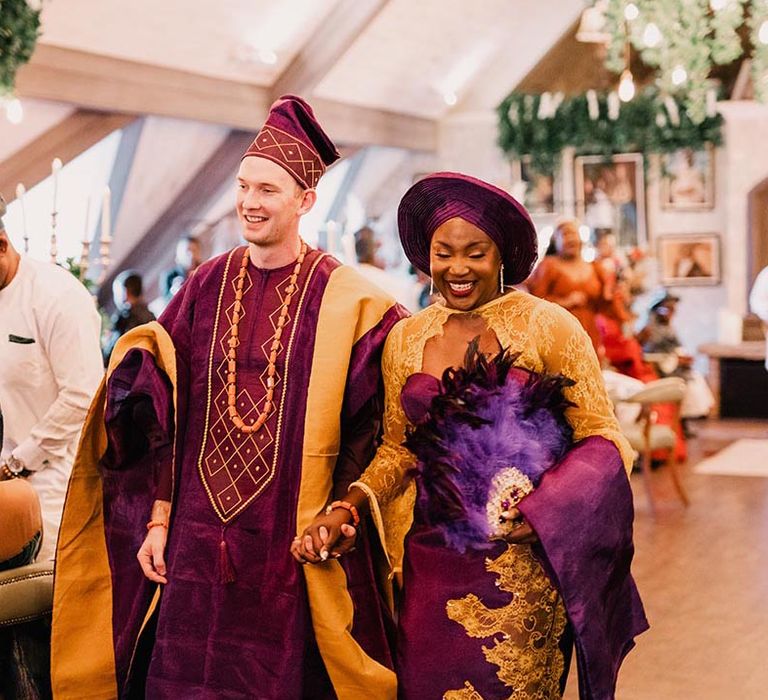 Nigerian wedding outfits for bride and groom wearing purple and gold attire 