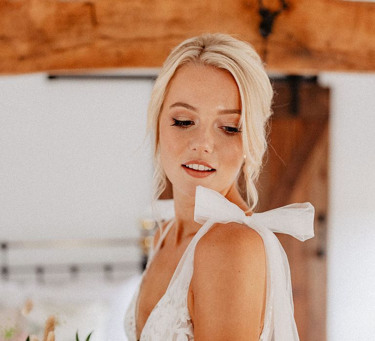 Bride wearing delicate wedding dress with tulle bow straps 