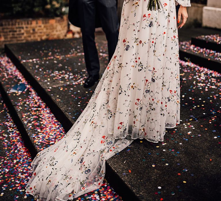 Colourful traditional wedding with bride in floral embroidery dress with groom in three piece morning suit 