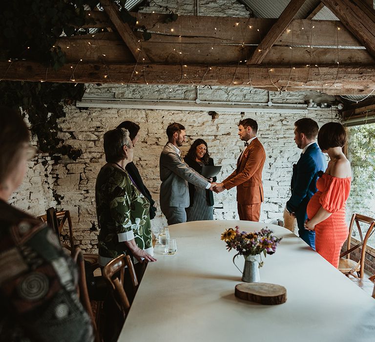 Grooms exchange their wedding vows at Wilde Lodge wedding venue in Wales 