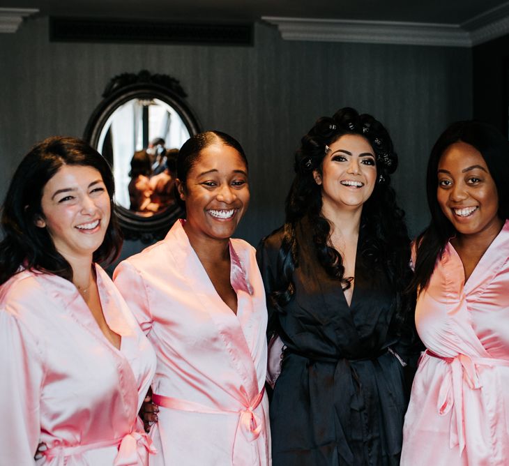 Bride and bridesmaids on the wedding morning in satin getting ready robes